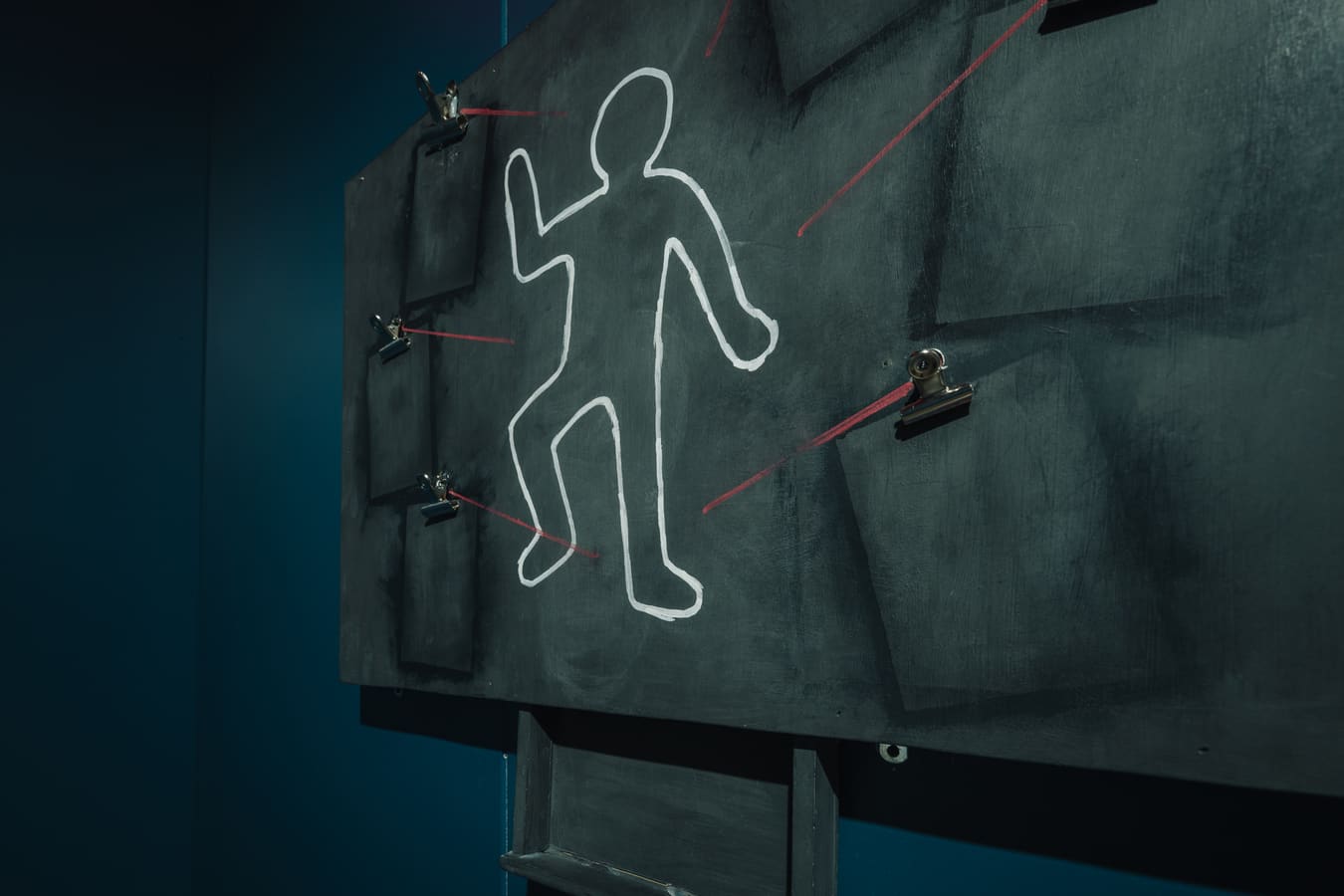 An evidence board with a chalk outline and red connecting lines inside Crime in the Alley.