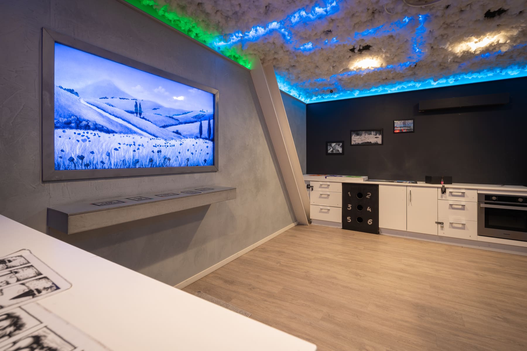A colourful artist’s studio illuminated in blue and green inside Lost Without Hue.